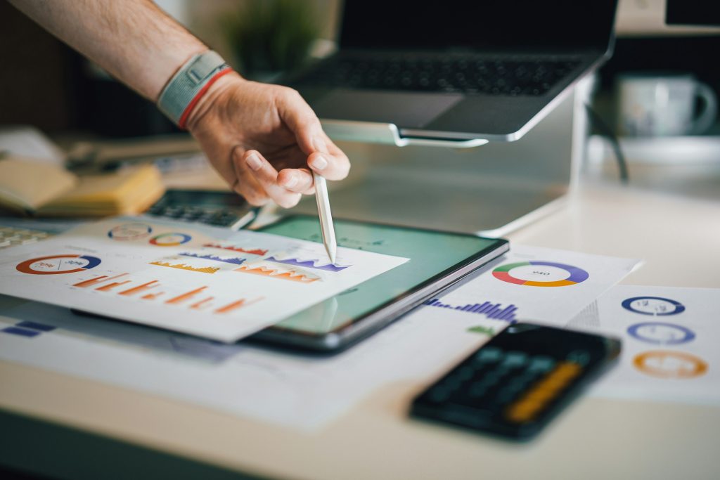 person pointing at a graph with pencil