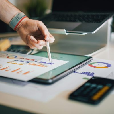 person pointing at a graph with pencil